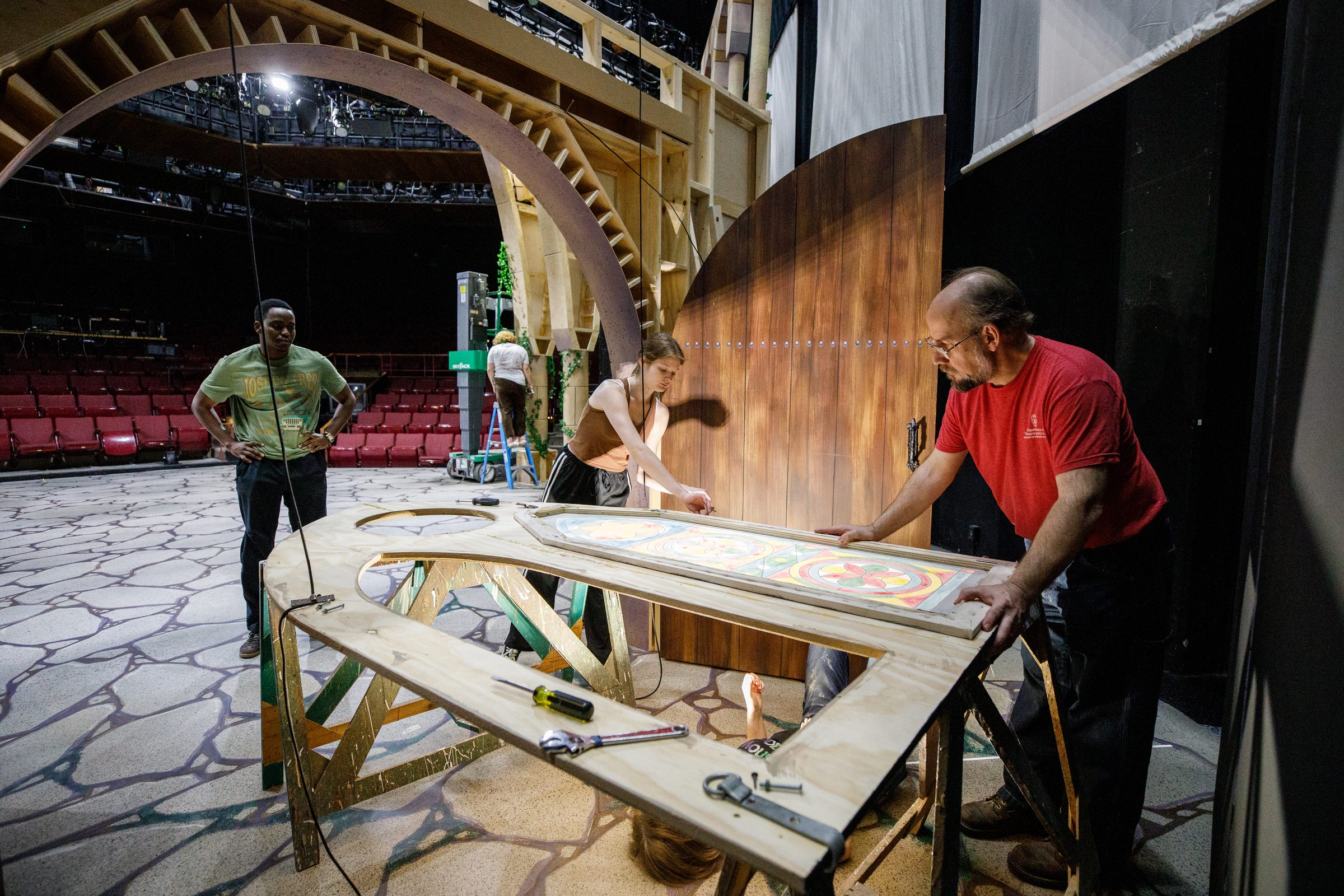 Theater instructor working on a set design with students.